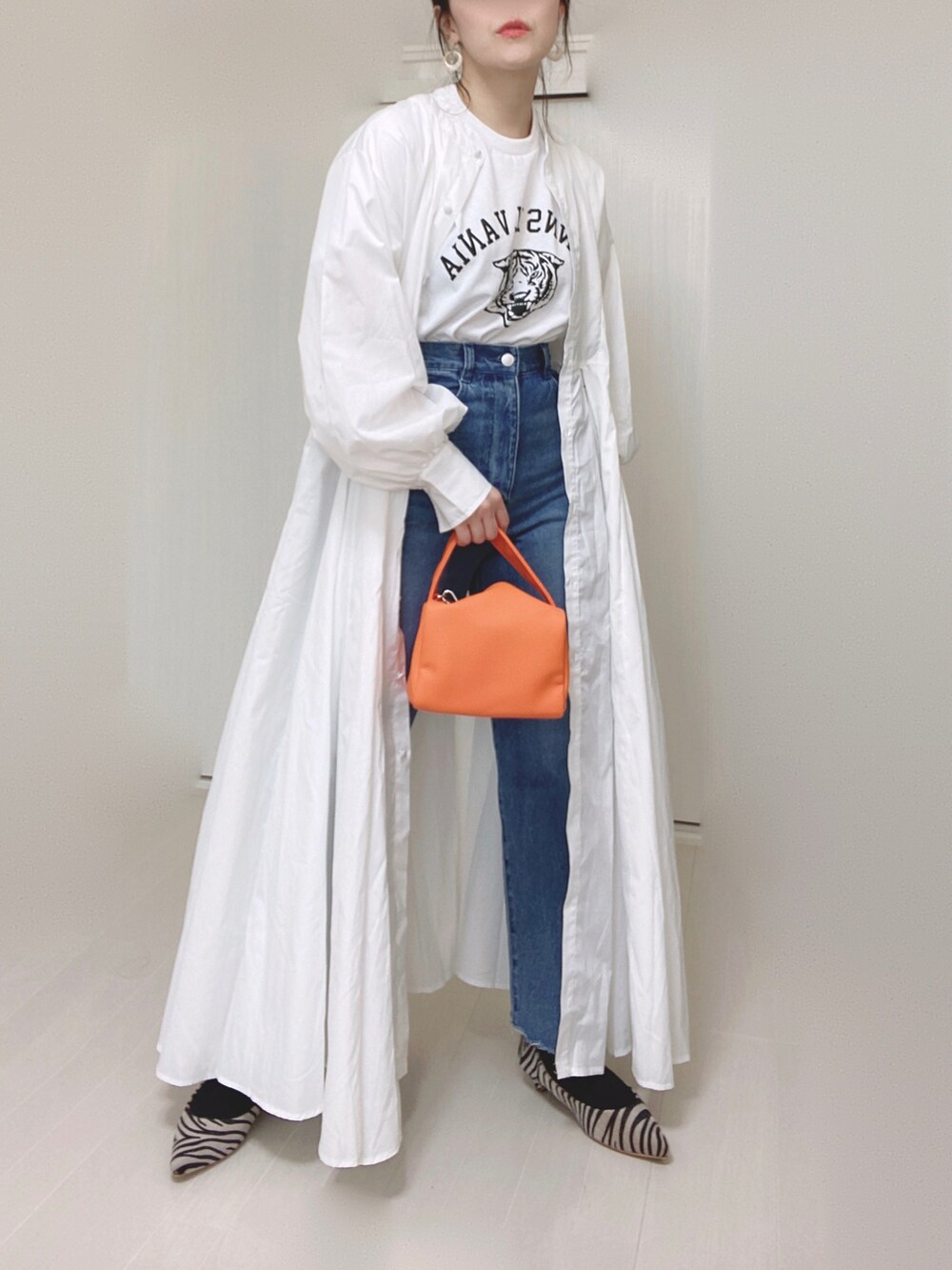 ホワイト系のTシャツ/カットソー、ホワイト系のシャツワンピース、ブルー系のデニムパンツを着用したレディースの春コーディネートの2枚目の写真