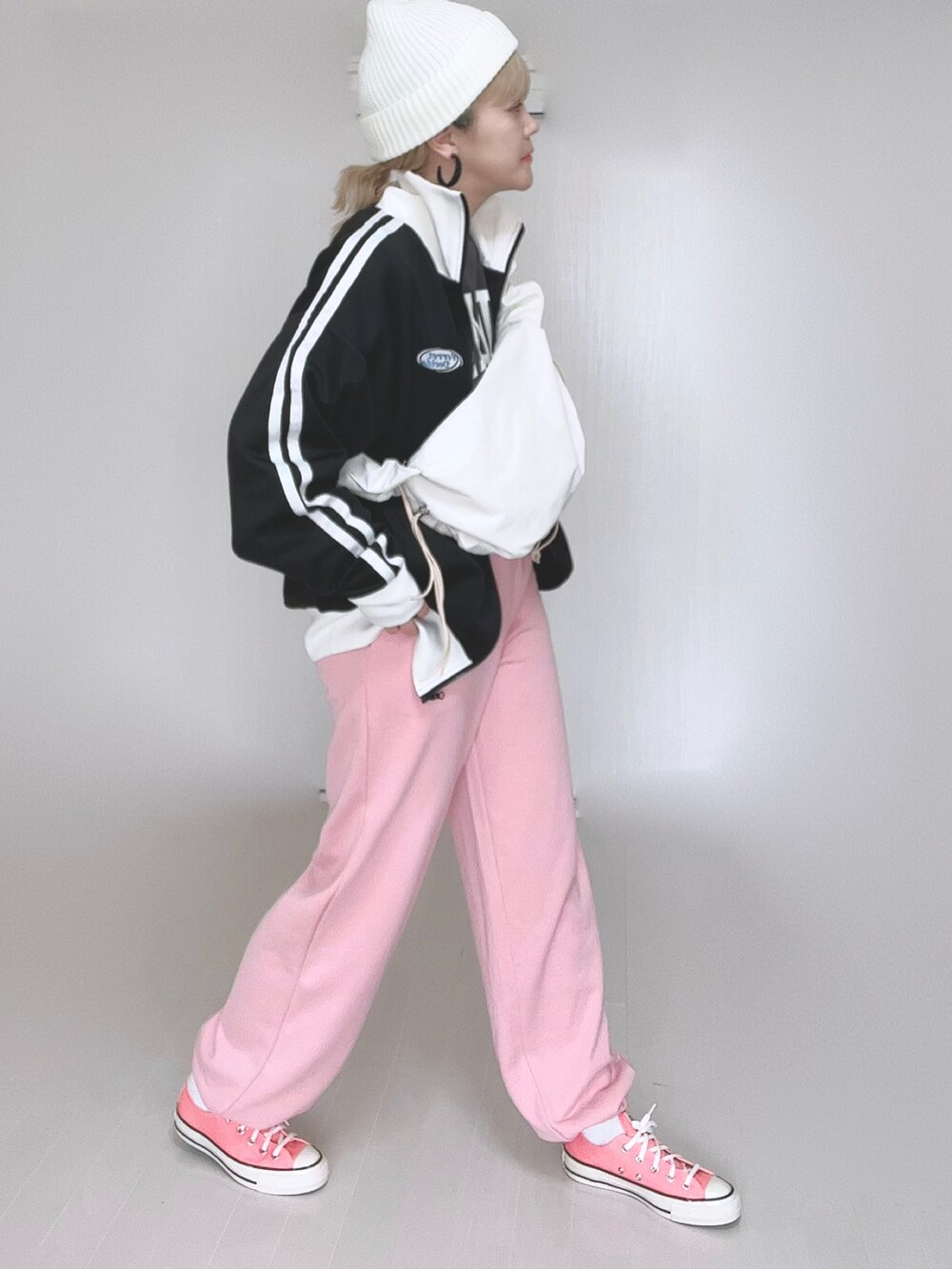 ホワイト系のショルダーバッグ、ブラック系のブルゾン、ピンク系のスウェットパンツを着用したレディースの冬コーディネートの3枚目の写真