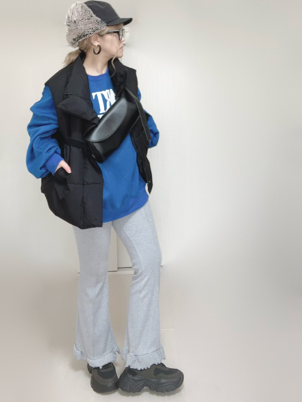 ブラック系のダウンベスト、グレー系のその他パンツ、ブラック系のスニーカーを着用したレディースの秋コーディネートの2枚目の写真