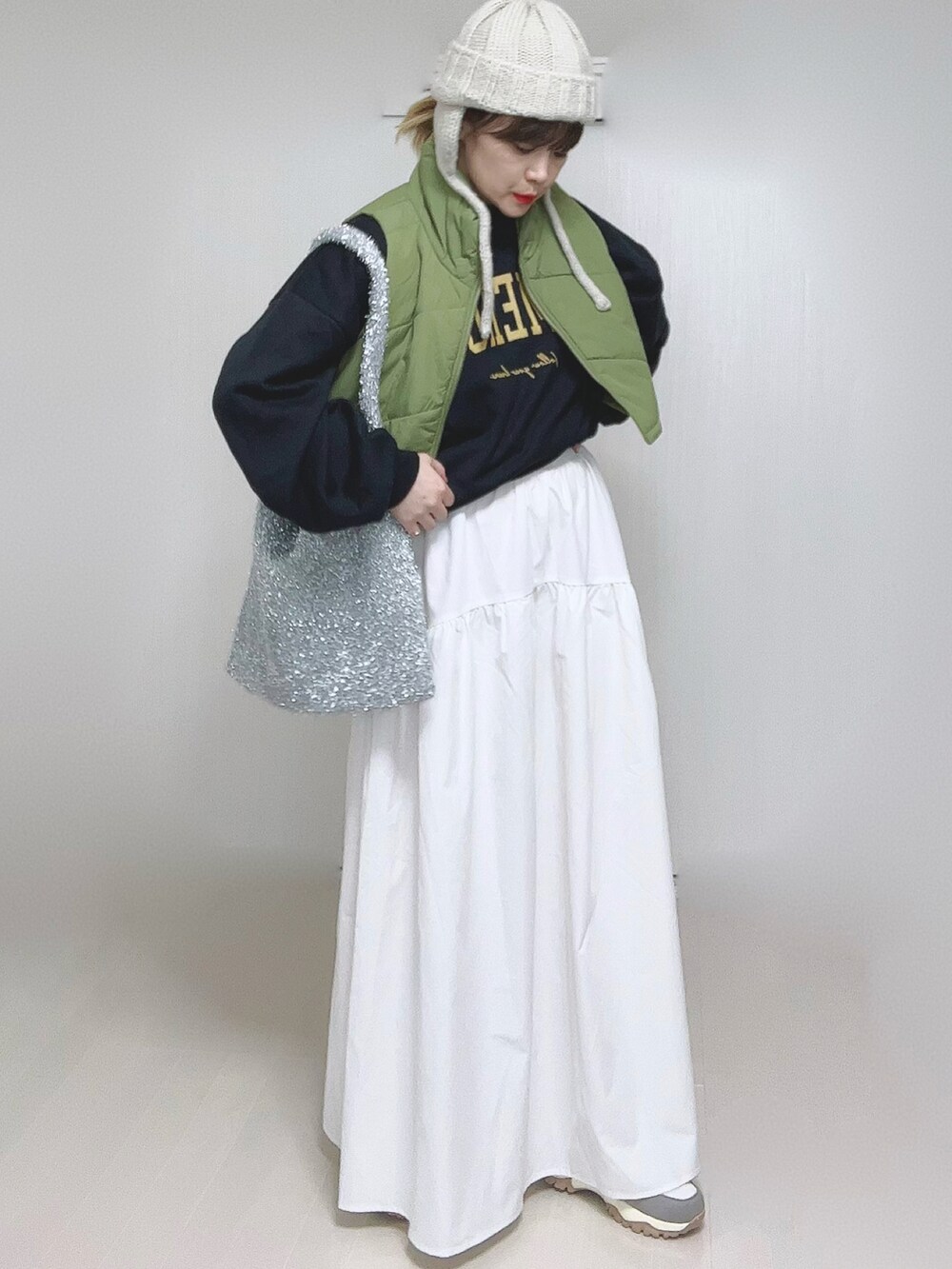 ホワイト系のスカート、ベージュ系のスニーカー、ベージュ系のニットキャップ/ビーニーを着用したレディースの冬コーディネートの3枚目の写真