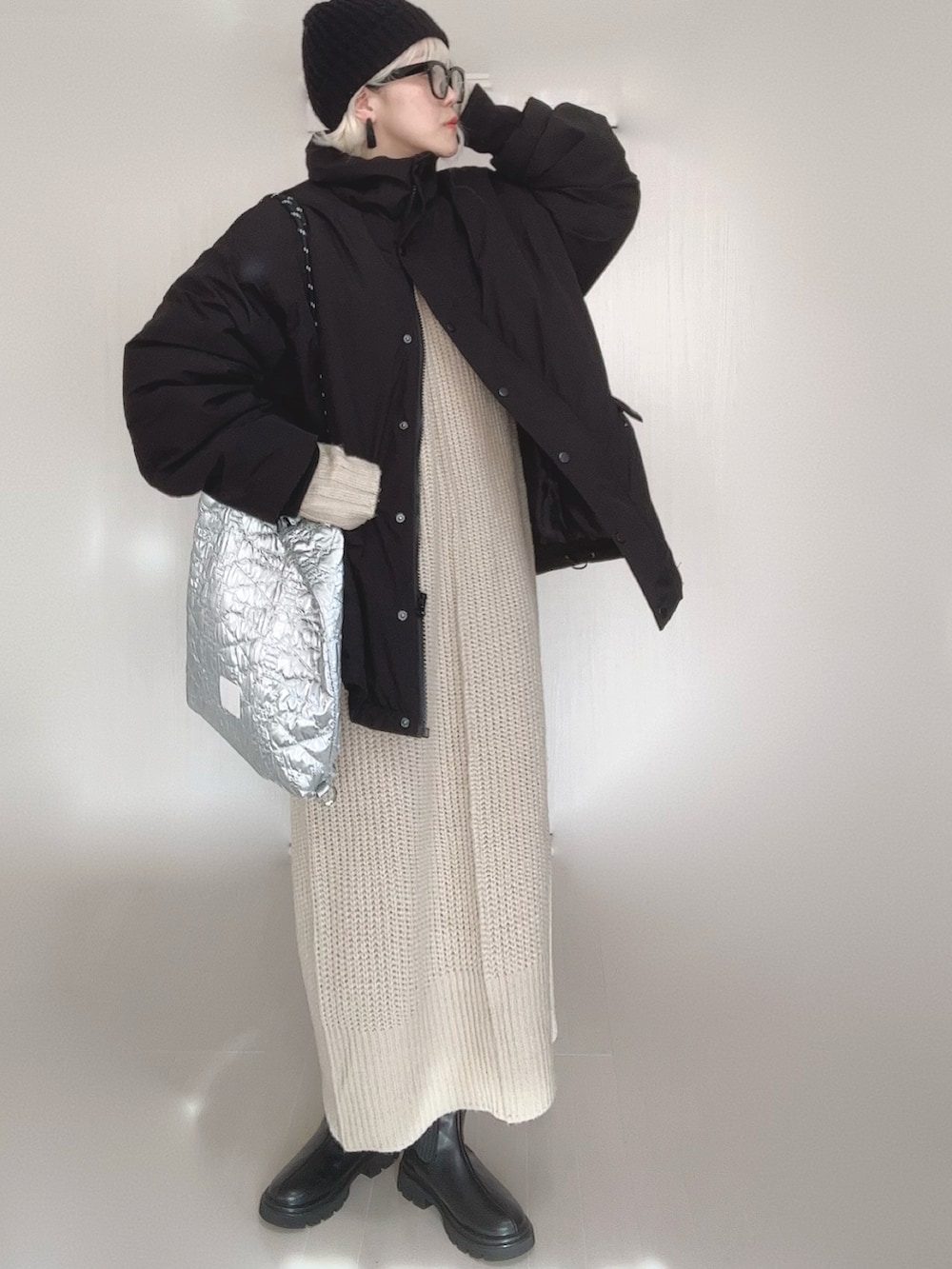 ブラック系のブルゾン、ホワイト系のワンピース、シルバー系のトートバッグを着用したレディースの冬コーディネートの2枚目の写真