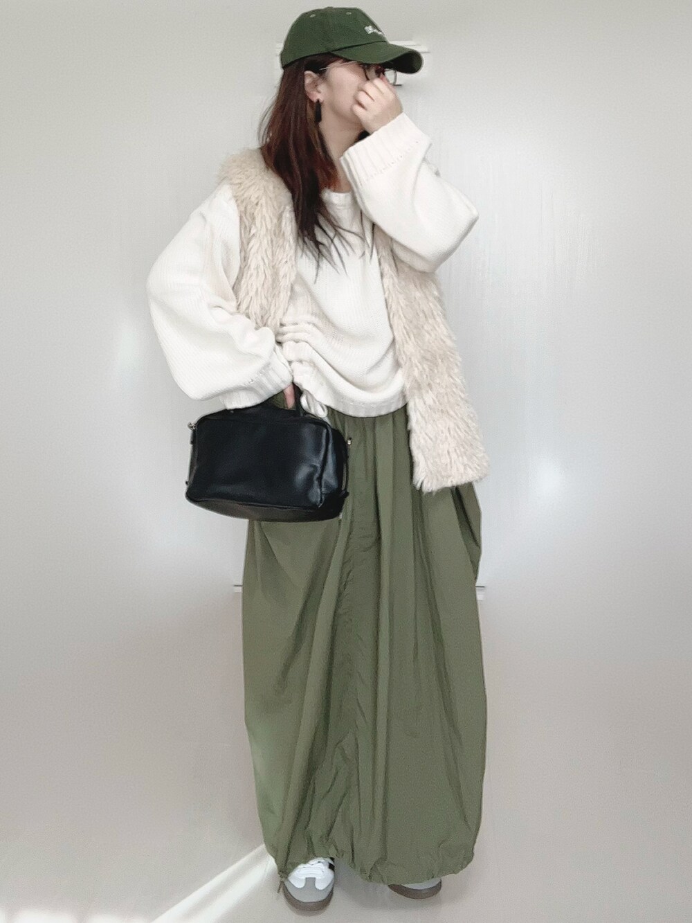 ホワイト系のニット/セーター、ホワイト系のベスト、ブラック系のボストンバッグを着用したレディースの秋コーディネートの3枚目の写真