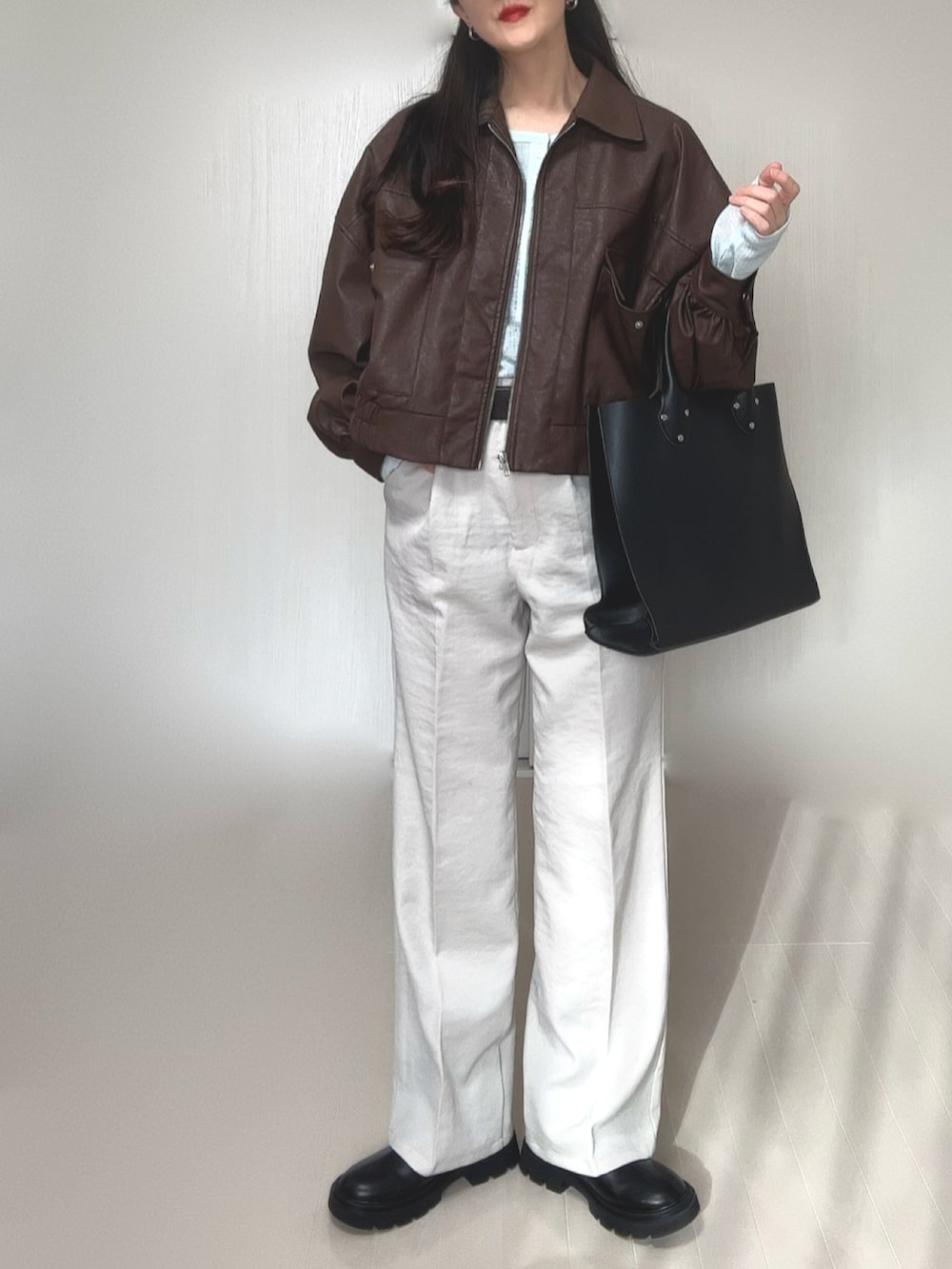 ブルー系のTシャツ/カットソー、ブラウン系のブルゾン、ブラック系のトートバッグを着用したレディースの冬コーディネートの4枚目の写真