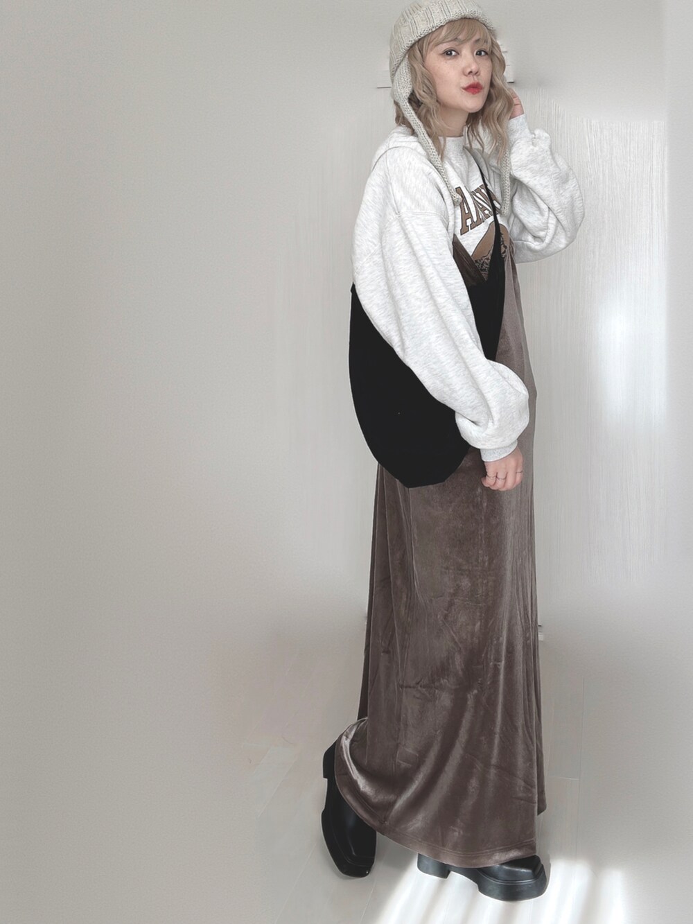 ブラウン系のワンピース、ホワイト系のTシャツ/カットソー、ブラック系のブーツを着用したレディースの秋コーディネートの4枚目の写真