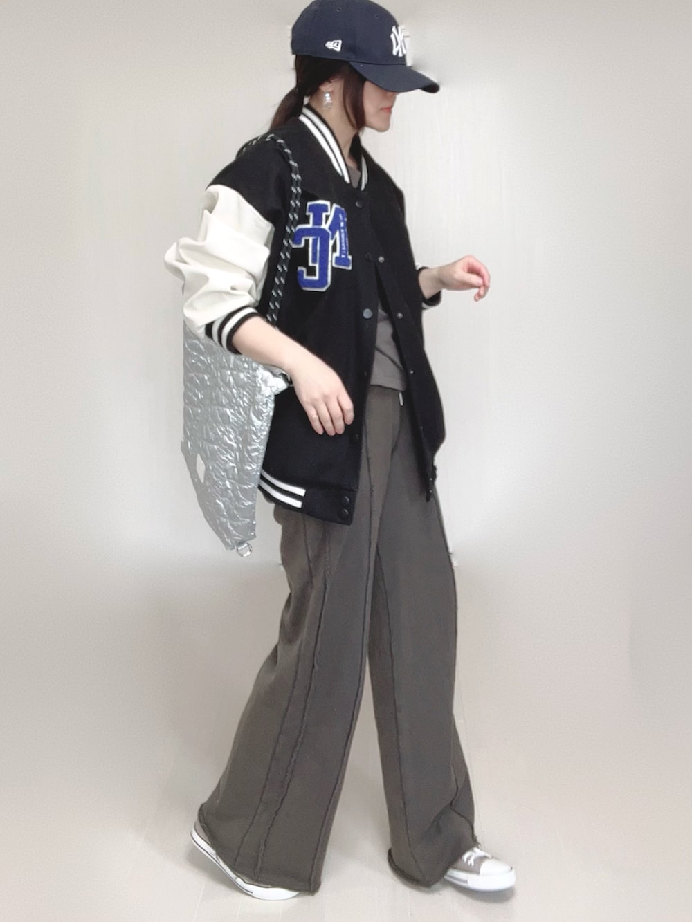 ブラック系のスウェットパンツ、ブラック系のスタジャン、シルバー系のトートバッグを着用したレディースの春コーディネートの5枚目の写真