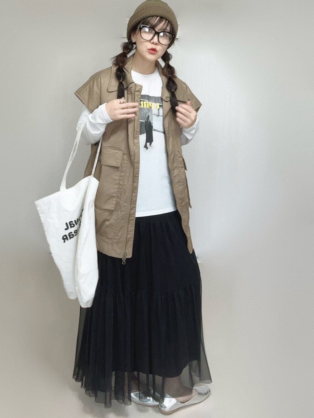 ブラック系のスカート、ホワイト系のTシャツ/カットソー、ベージュ系のジャケット/アウターを着用したレディースの秋コーディネートの4枚目の写真