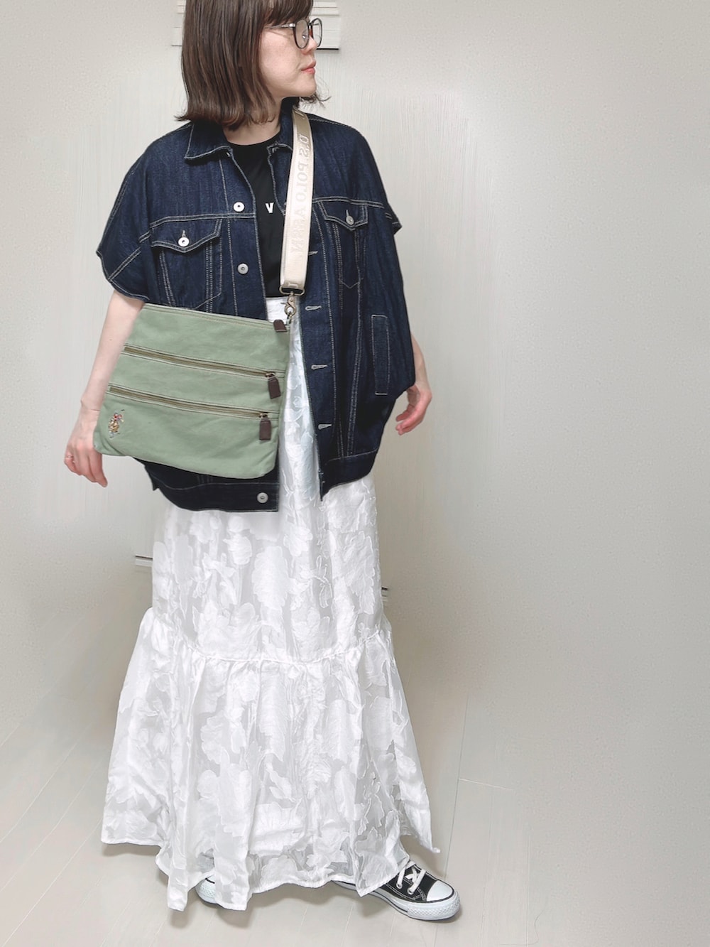 グリーン系のショルダーバッグ、ブラック系のTシャツ/カットソー、ブルー系のベストを着用したレディースの春コーディネートの4枚目の写真