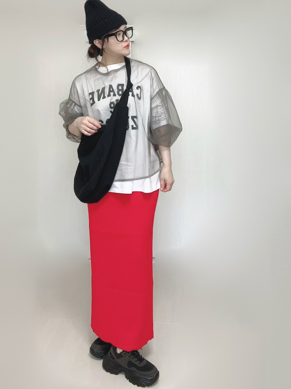 ホワイト系のTシャツ/カットソー、レッド系のスカート、ブラック系のスニーカーを着用したレディースの春コーディネートの3枚目の写真