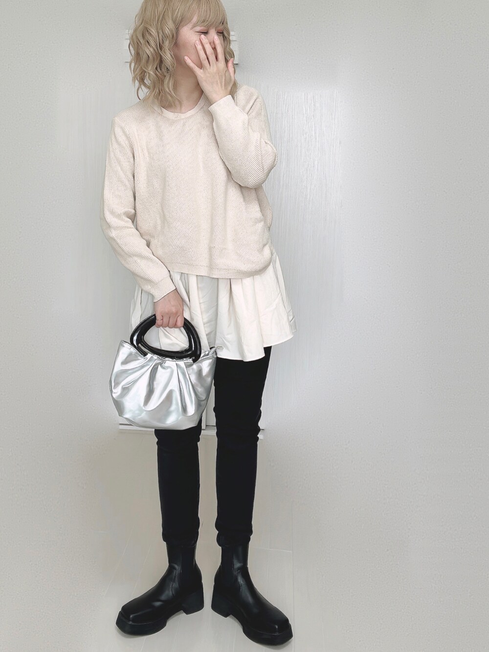 ベージュ系のニット/セーター、ブラック系のデニムパンツを着用したレディースの秋コーディネートの4枚目の写真