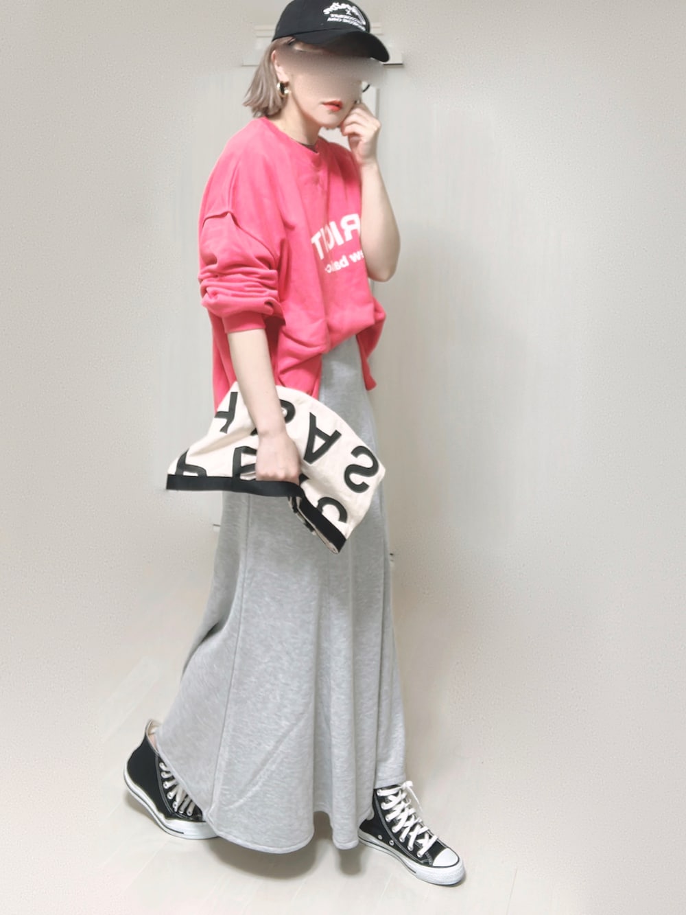 ピンク系のスウェット、ホワイト系のトートバッグ、グレー系のスカートを着用したレディースの夏コーディネートの2枚目の写真