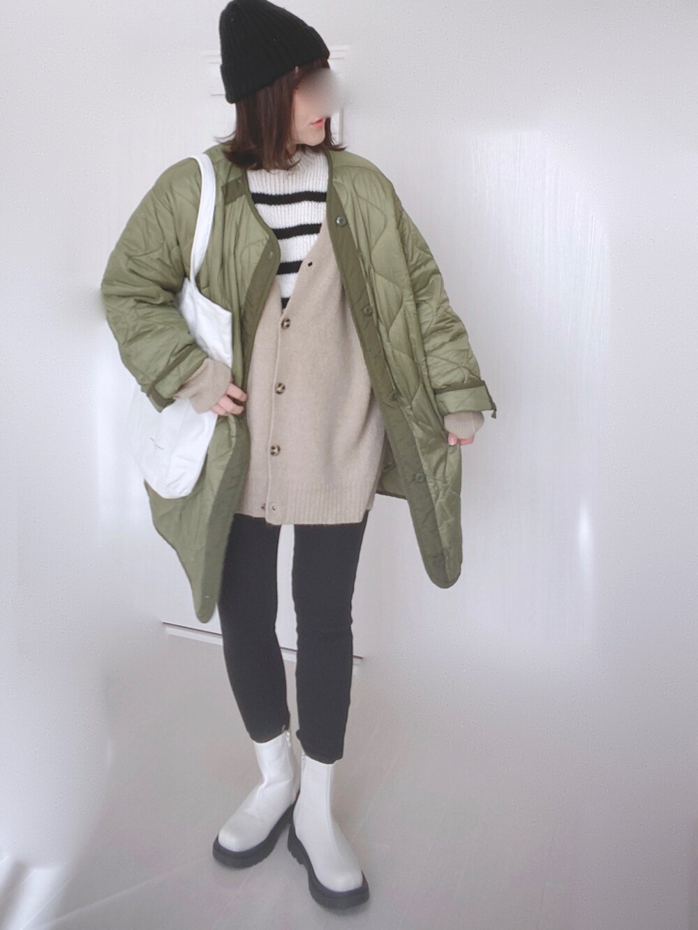 ホワイト系のニット/セーター、ベージュ系のカーディガン/ボレロ、ホワイト系のブーツを着用したレディースの冬コーディネートの5枚目の写真