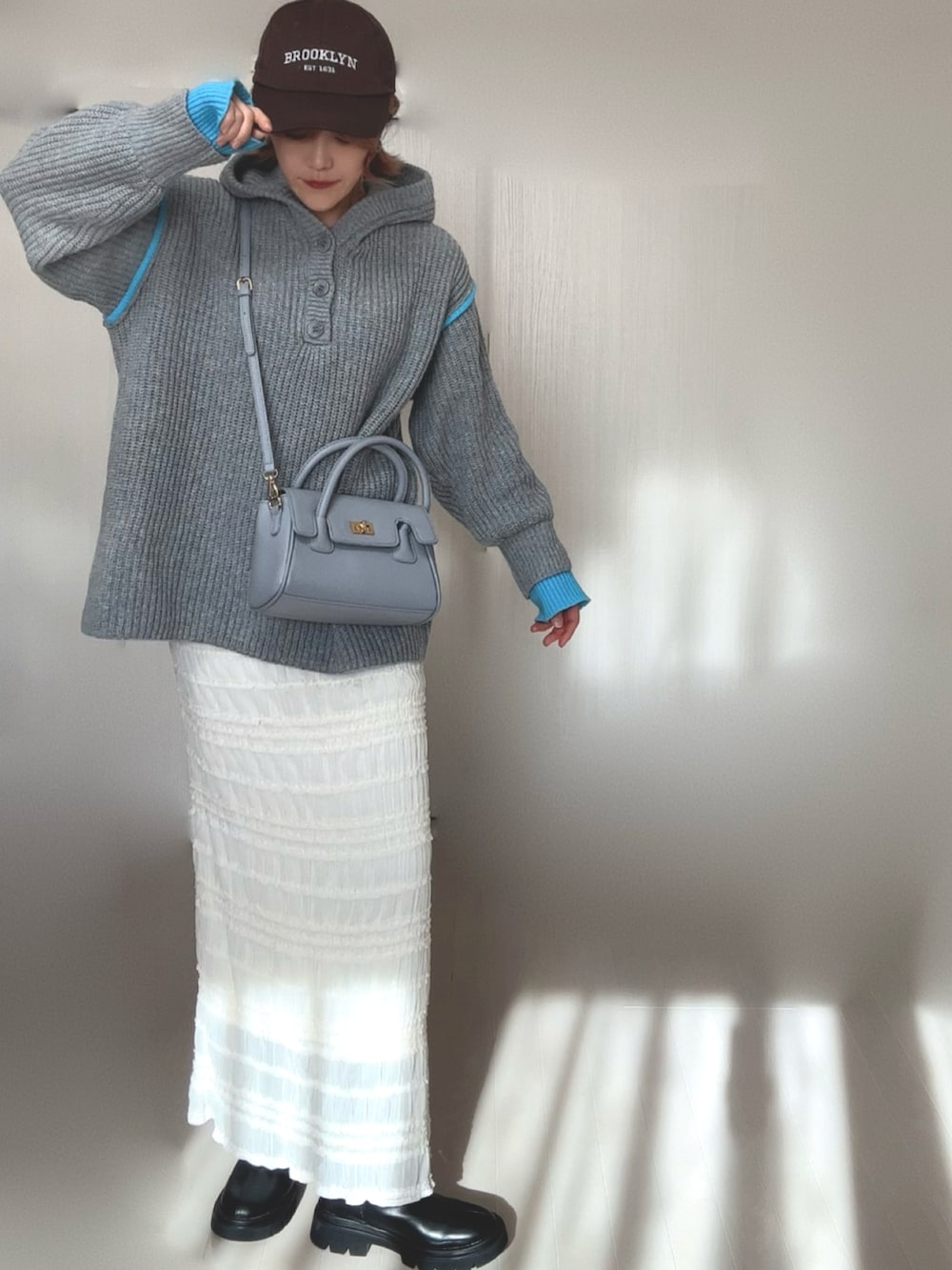 グレー系のニット/セーター、ブラック系のブーツ、ブラウン系のテーラードジャケットを着用したレディースの冬コーディネートの2枚目の写真