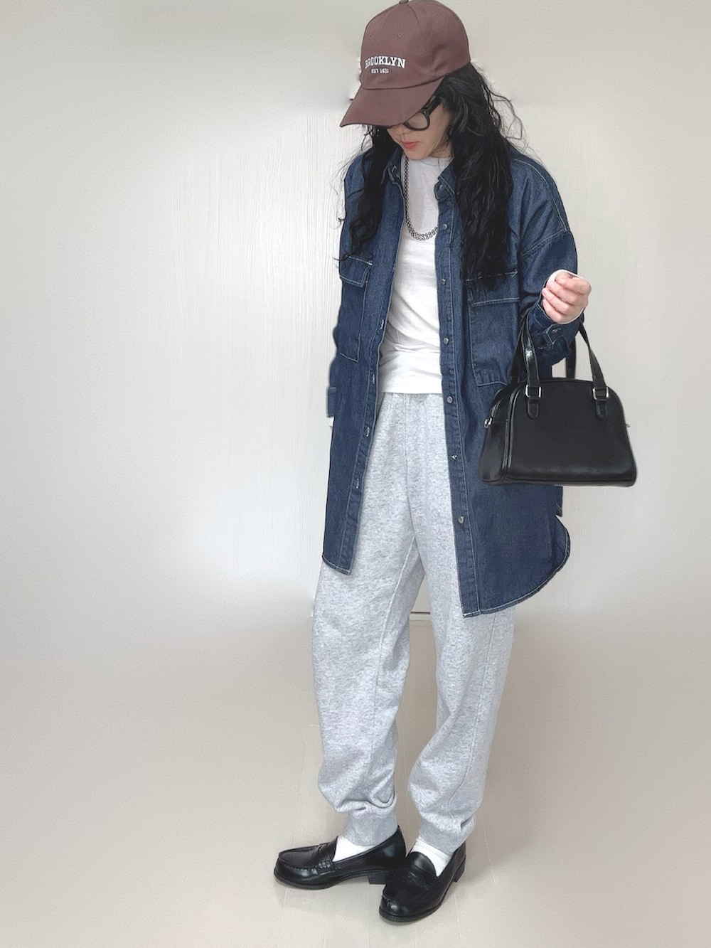 ブルー系のシャツ/ブラウス、ブラック系のボストンバッグ、ブラック系のローファーを着用したレディースの春コーディネートの2枚目の写真