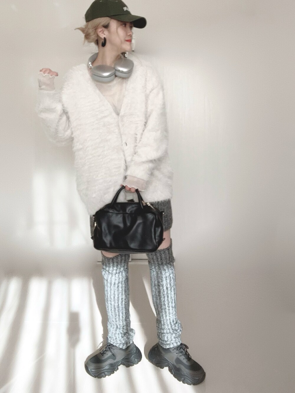 ホワイト系のカーディガン/ボレロ、グレー系のその他パンツ、ブラック系のボストンバッグを着用したレディースの冬コーディネートの5枚目の写真