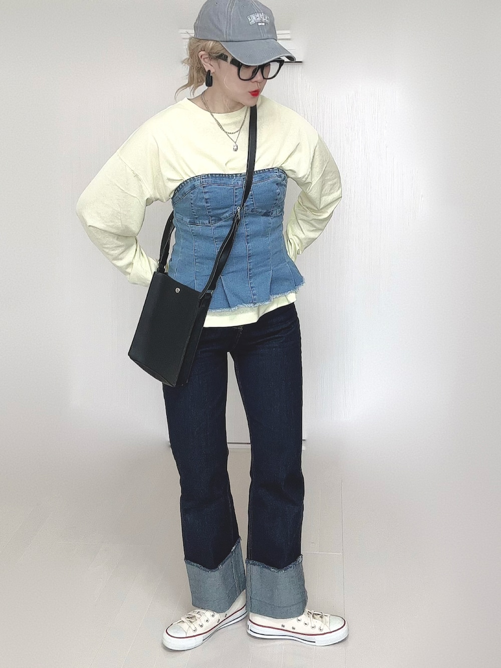 イエロー系のTシャツ/カットソー、ブラック系のショルダーバッグ、ブルー系のデニムパンツを着用したレディースの春コーディネートの3枚目の写真