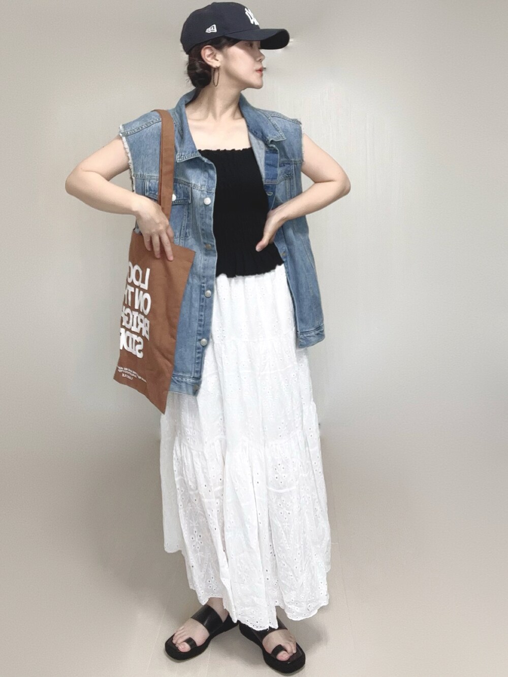 ブラック系のキャミソール、ブラウン系のトートバッグ、ブラック系のサンダルを着用したレディースの夏コーディネートの4枚目の写真