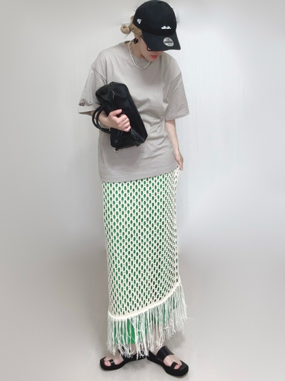 ホワイト系のスカート、ベージュ系のTシャツ/カットソー、ブラック系のサンダルを着用したレディースの夏コーディネートの5枚目の写真