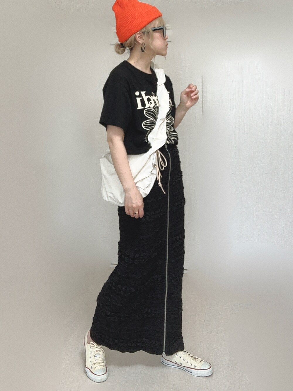 ブラック系のスカート、ホワイト系のショルダーバッグ、ブラック系のTシャツ/カットソーを着用したレディースの夏コーディネートの5枚目の写真