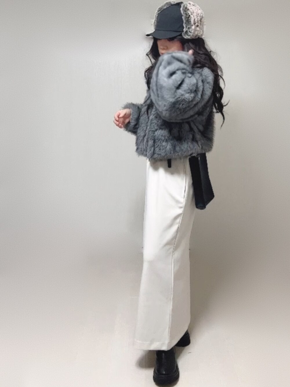 グレー系のブルゾン、ブラック系のブーツ、ホワイト系のワンピースを着用したレディースの秋コーディネートの5枚目の写真