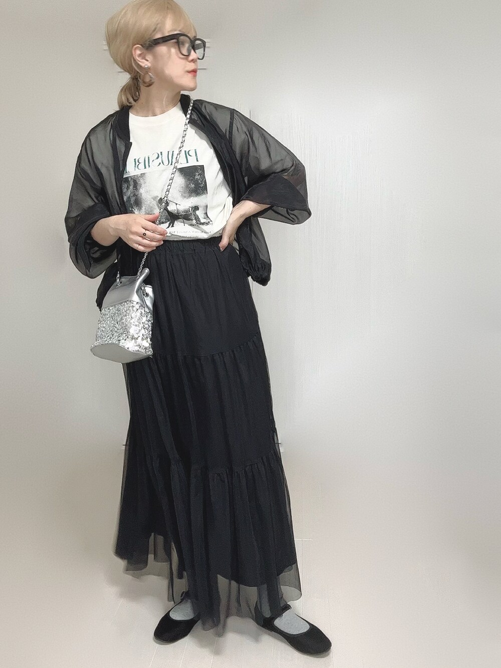 ブラック系のスカート、ホワイト系のTシャツ/カットソー、シルバー系のショルダーバッグを着用したレディースの秋コーディネートの5枚目の写真