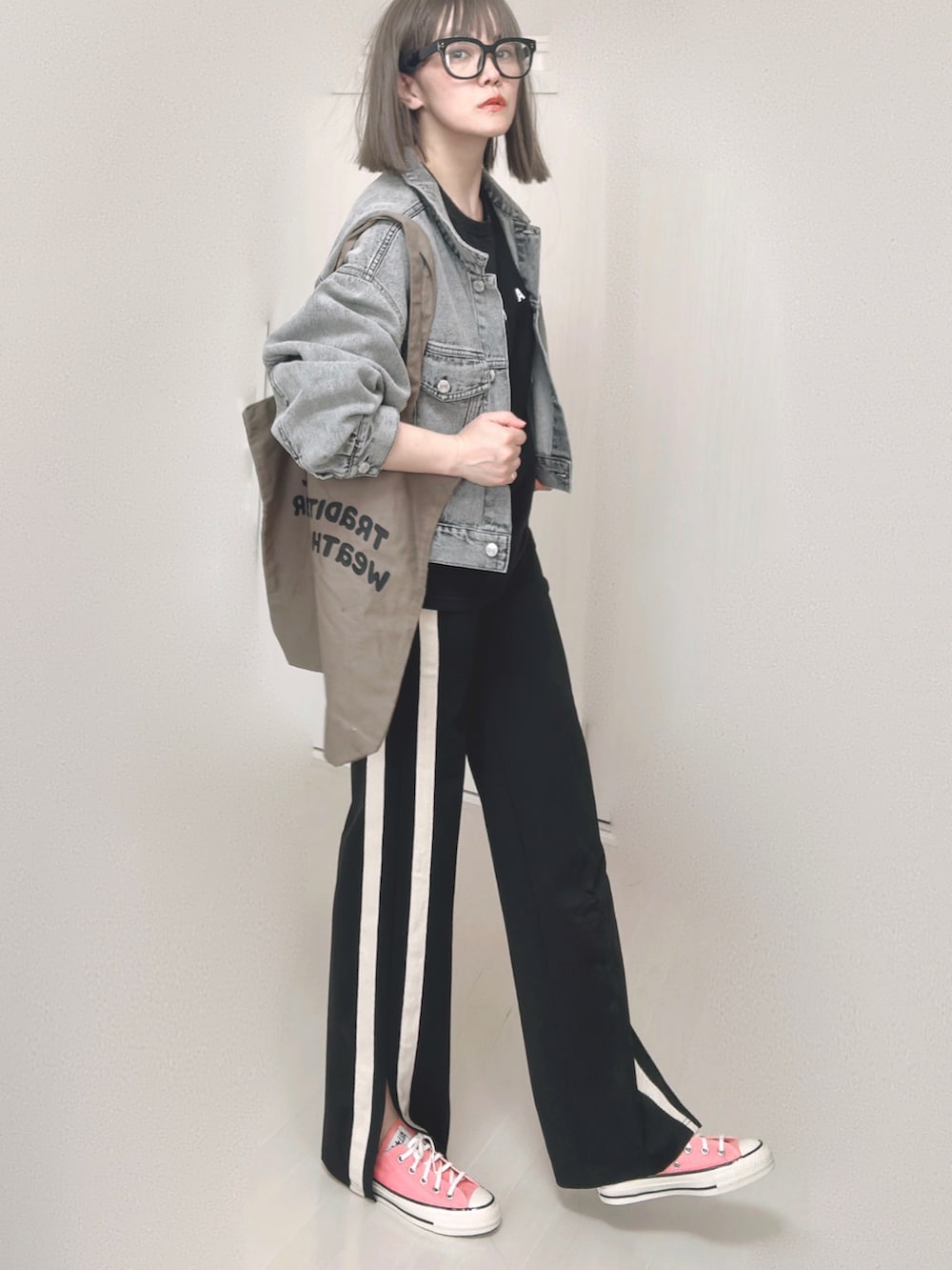 ブラック系のTシャツ/カットソー、ブラック系のデニムジャケット、ブラウン系のトートバッグを着用したレディースの秋コーディネートの3枚目の写真