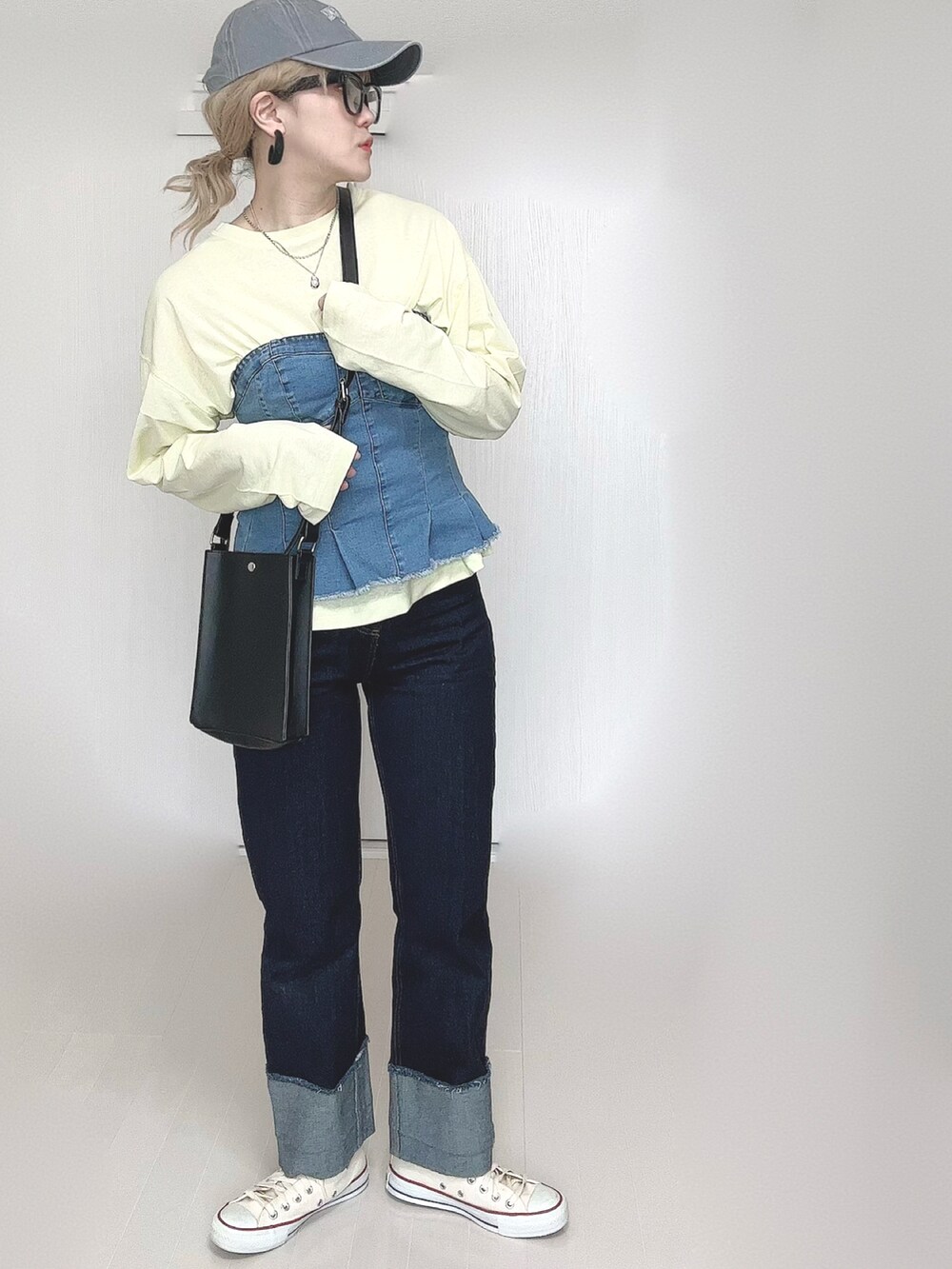 イエロー系のTシャツ/カットソー、ブラック系のショルダーバッグ、ブルー系のデニムパンツを着用したレディースの春コーディネートの4枚目の写真