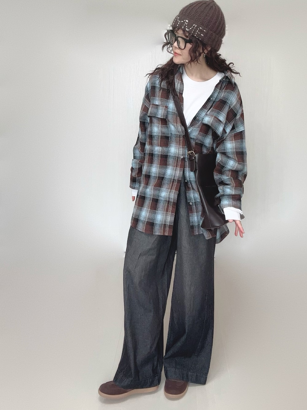 ブラウン系のシャツ/ブラウス、ホワイト系のTシャツ/カットソー、ブラック系のデニムパンツを着用したレディースの冬コーディネートの3枚目の写真