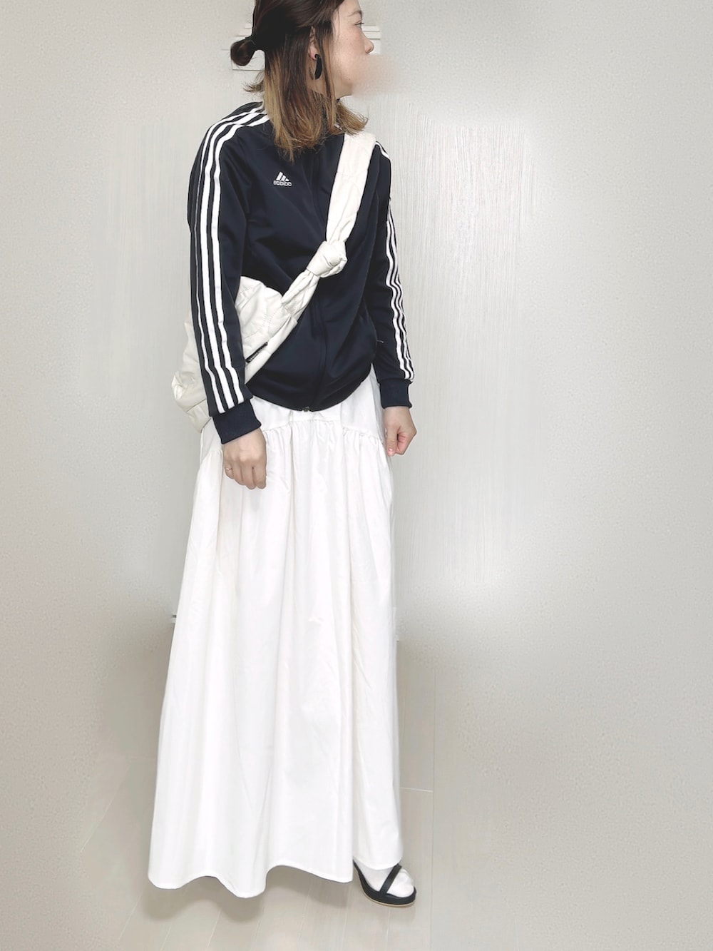 ブルー系のナイロンジャケット、ホワイト系のショルダーバッグ、ホワイト系のスカートを着用したレディースの秋コーディネートの3枚目の写真