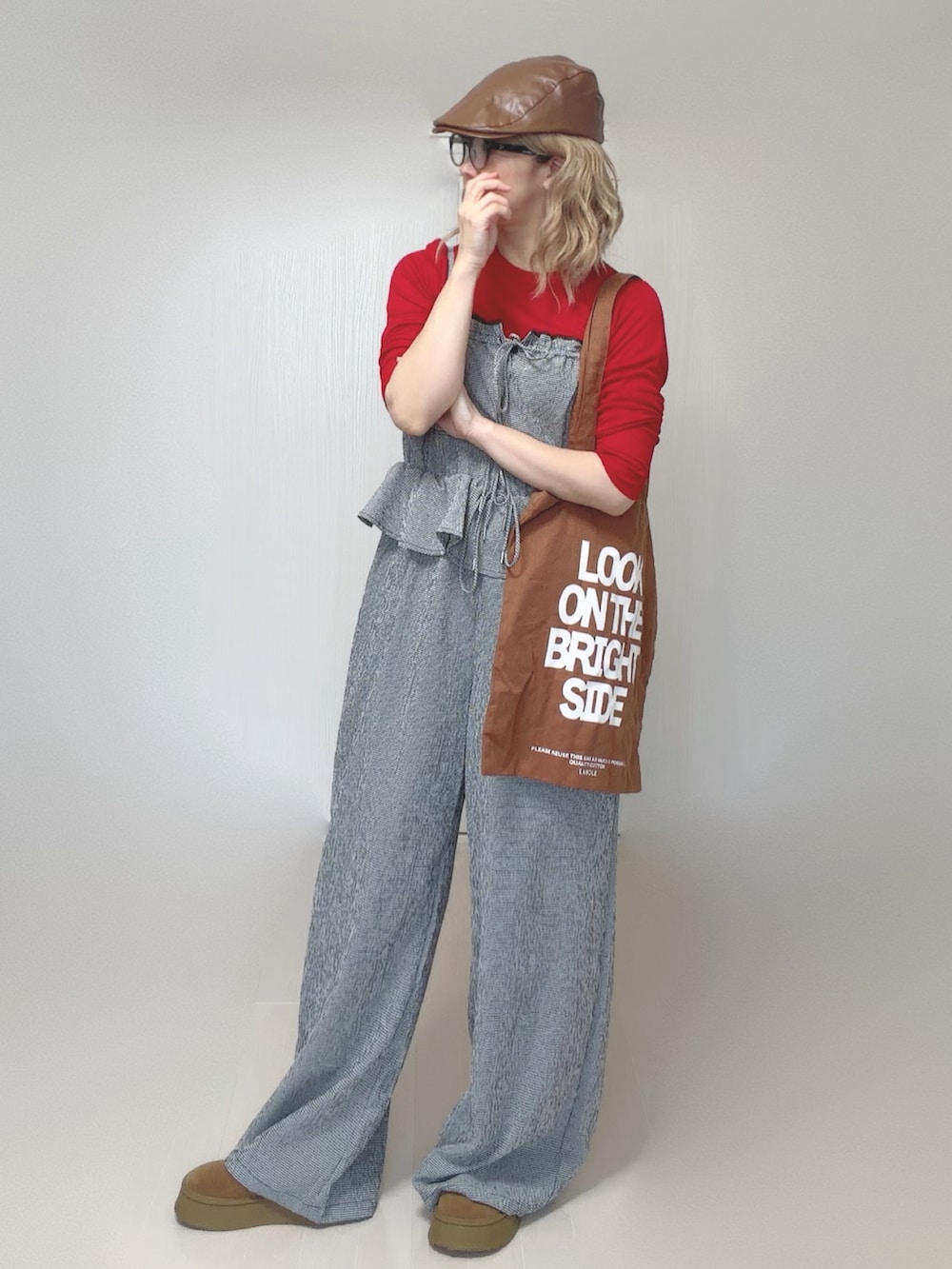 グレー系のサロペット/オーバーオール、ブラウン系のトートバッグ、レッド系のTシャツ/カットソーを着用したレディースの夏コーディネートの4枚目の写真