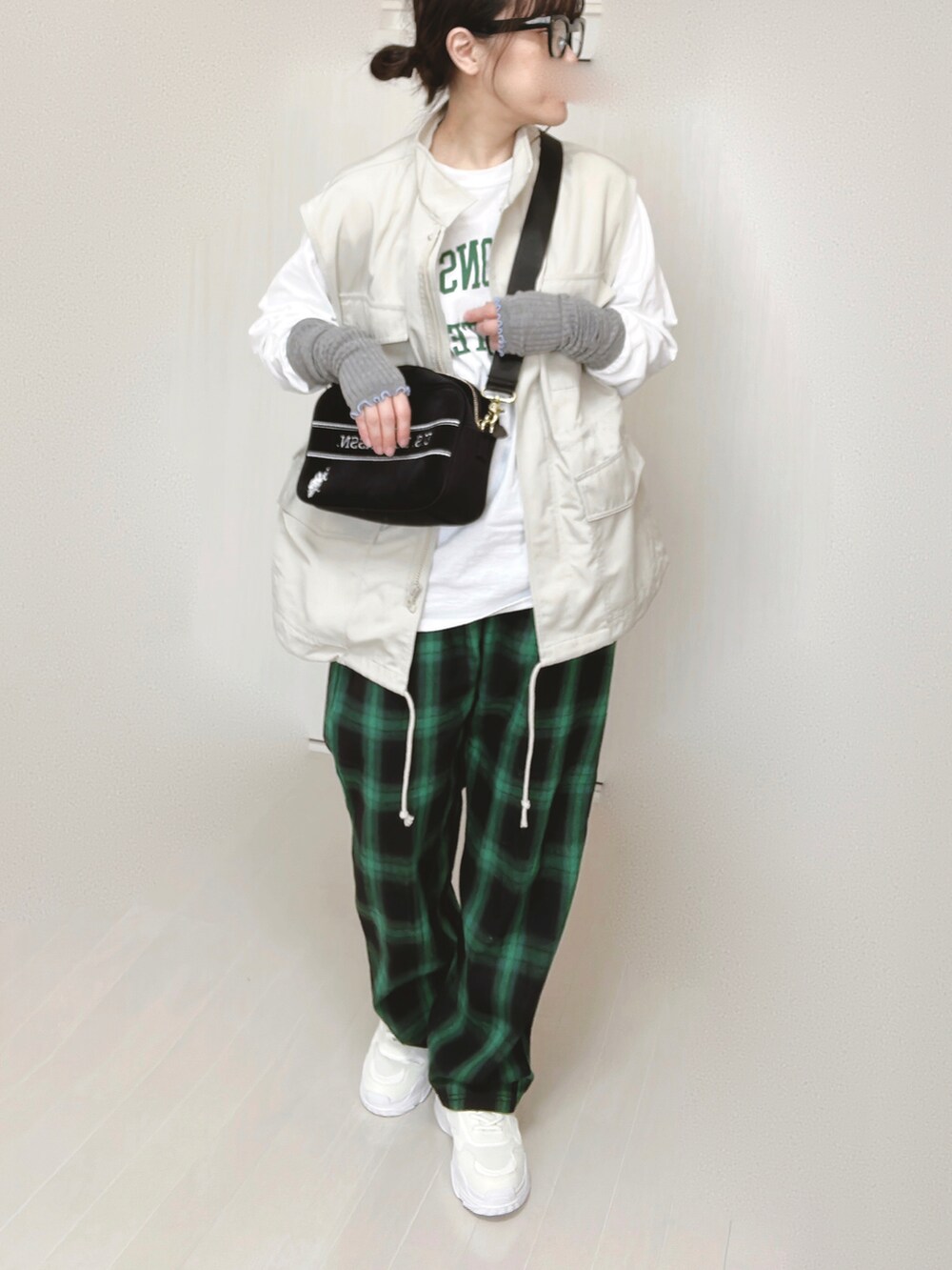 ホワイト系のTシャツ/カットソー、ホワイト系のベスト、ブラック系のショルダーバッグを着用したレディースの春コーディネートの5枚目の写真