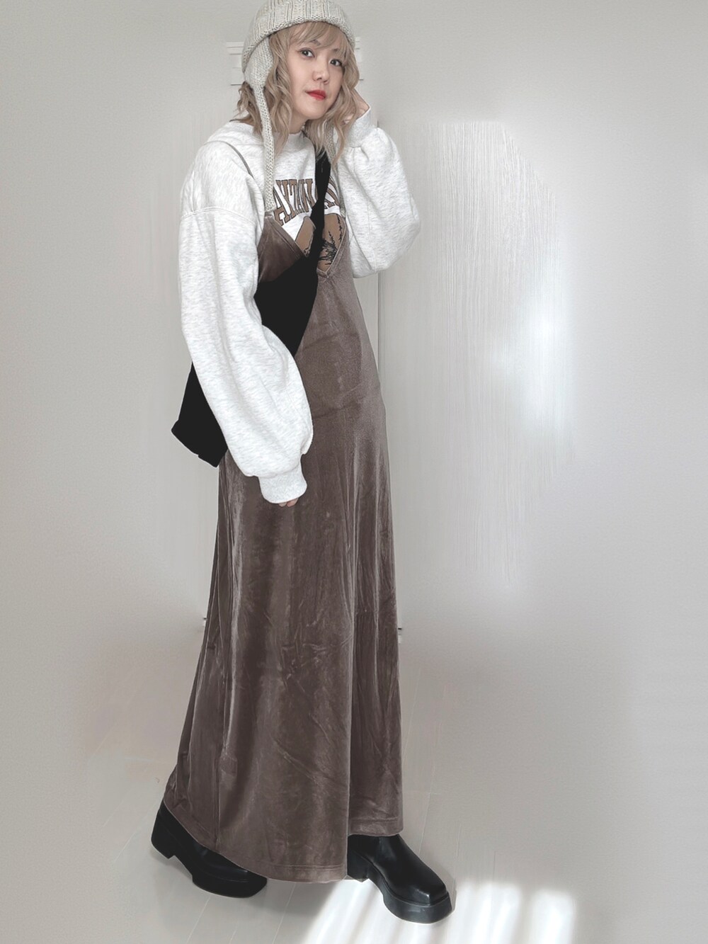 ブラウン系のワンピース、ホワイト系のTシャツ/カットソー、ブラック系のブーツを着用したレディースの秋コーディネートの3枚目の写真