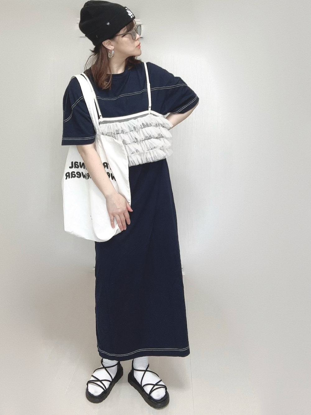 ブルー系のワンピース、ホワイト系のトートバッグ、ブラック系のサンダルを着用したレディースの春コーディネートの2枚目の写真