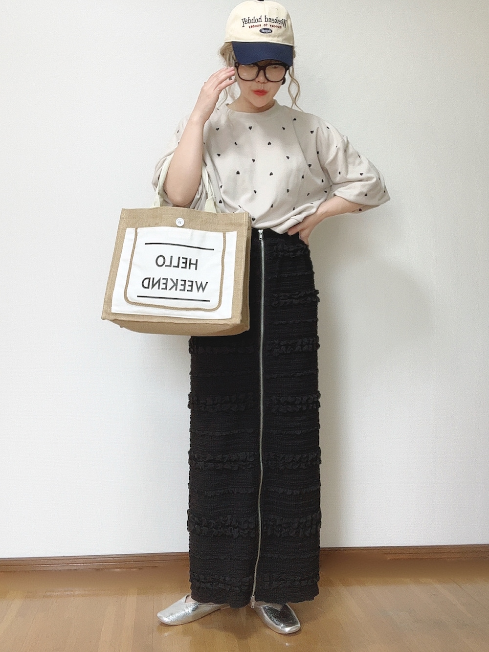 ブラック系のスカート、ホワイト系のかごバッグ、シルバー系のパンプスを着用したレディースの夏コーディネートの3枚目の写真