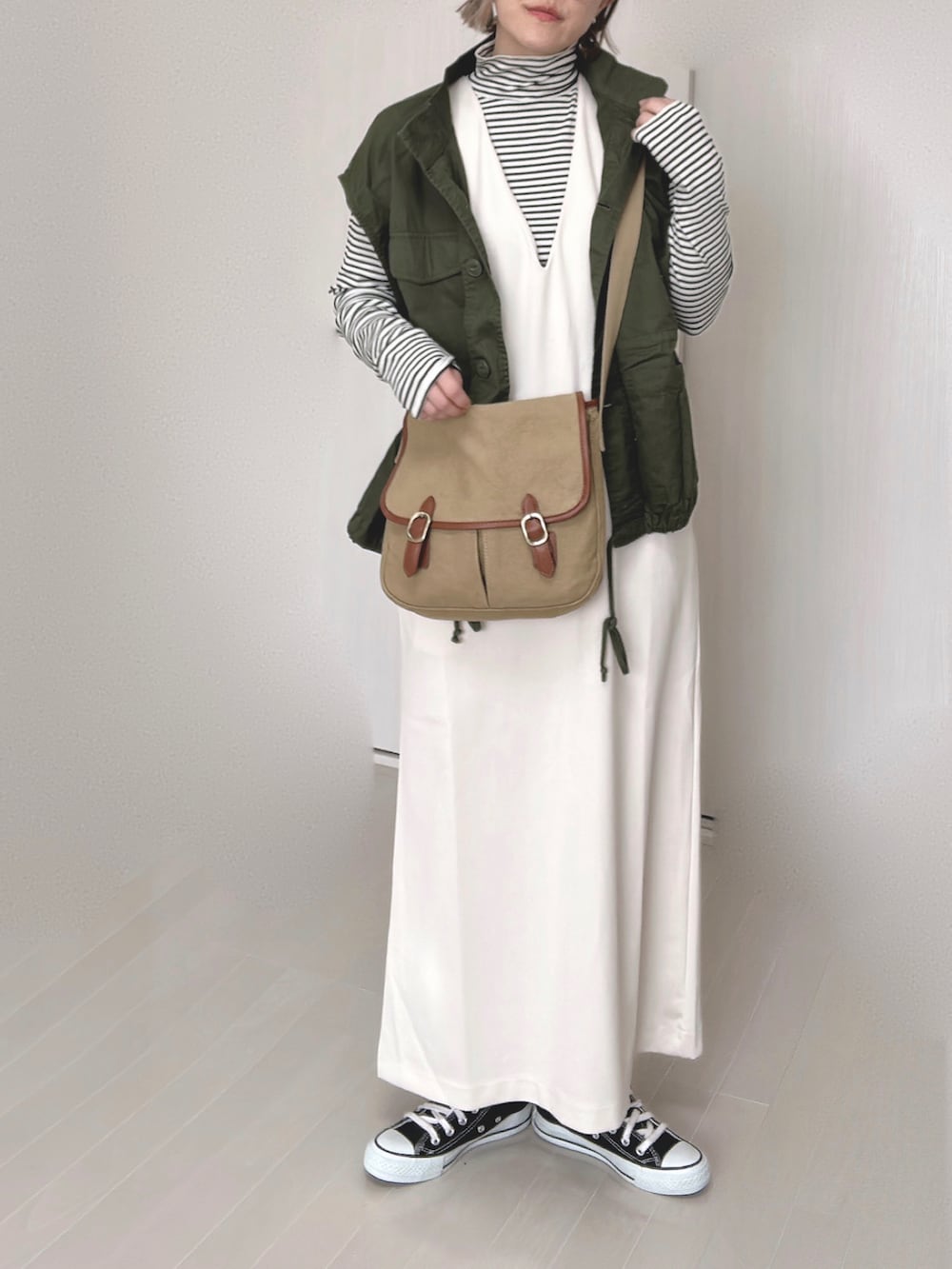 ホワイト系のワンピース、ホワイト系のTシャツ/カットソー、グリーン系のその他アウターを着用したレディースの冬コーディネートの3枚目の写真