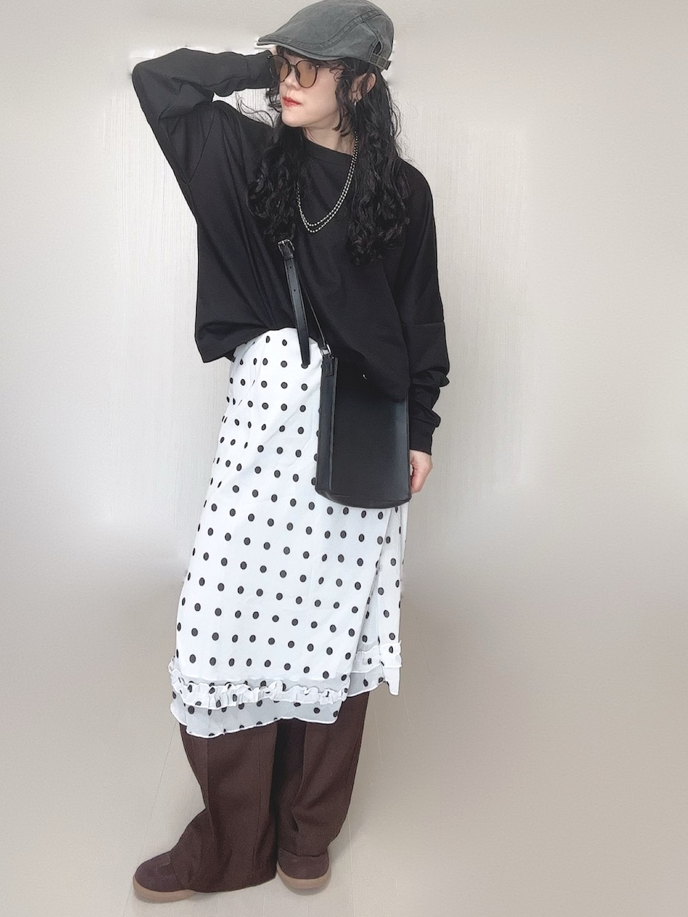 ブラック系のスウェット、ブラウン系のその他パンツ、ブラック系のショルダーバッグを着用したレディースの春コーディネートの5枚目の写真