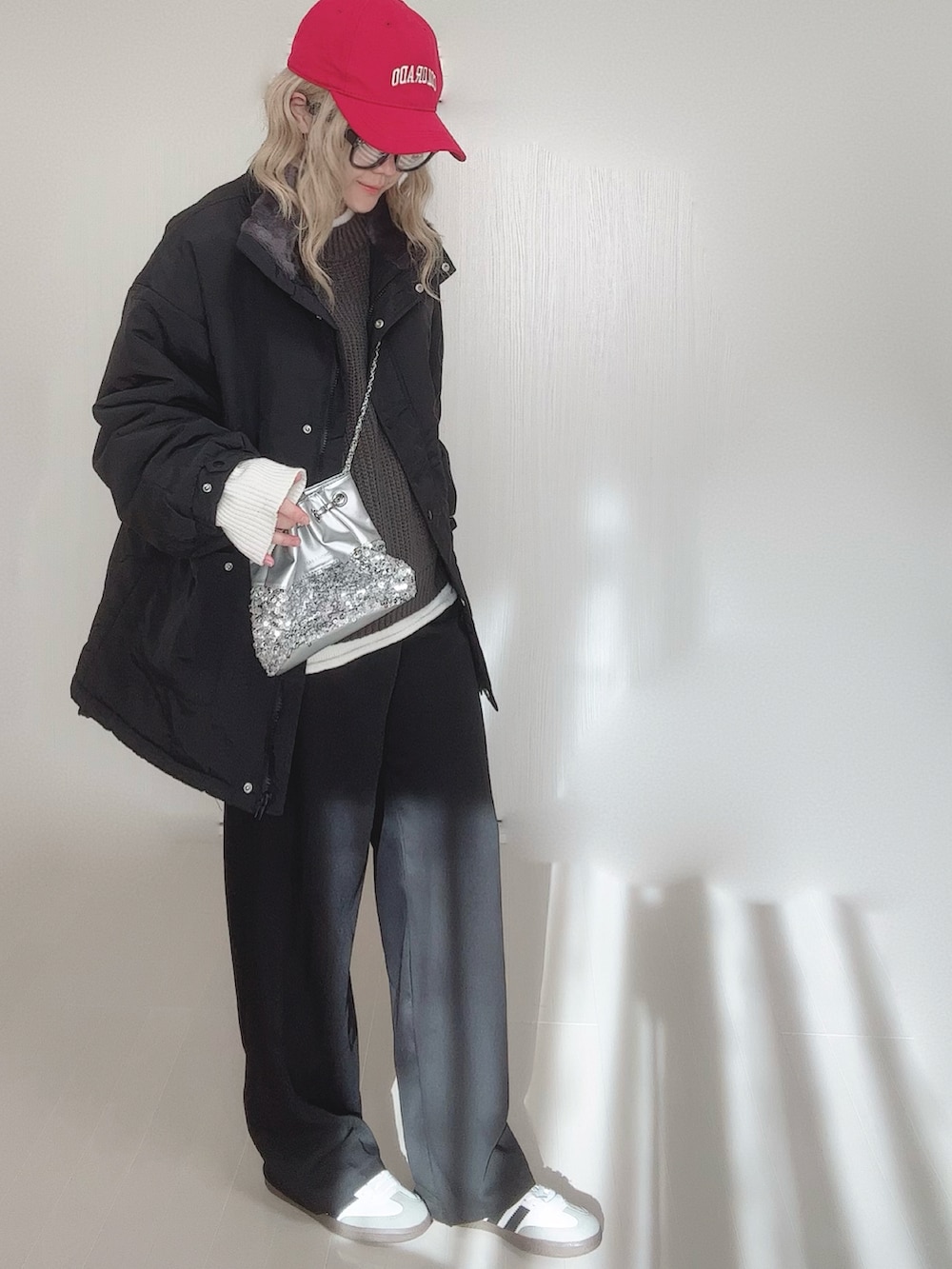ブラック系のブルゾン、グレー系のニット/セーター、シルバー系のショルダーバッグを着用したレディースの冬コーディネートの4枚目の写真