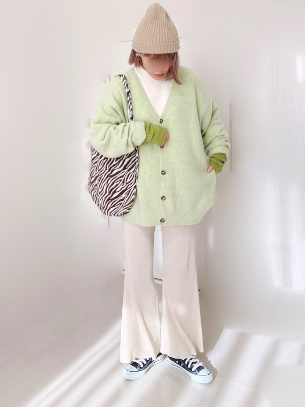 グリーン系のカーディガン/ボレロ、ホワイト系のニット/セーター、ホワイト系のその他パンツを着用したレディースの冬コーディネートの2枚目の写真
