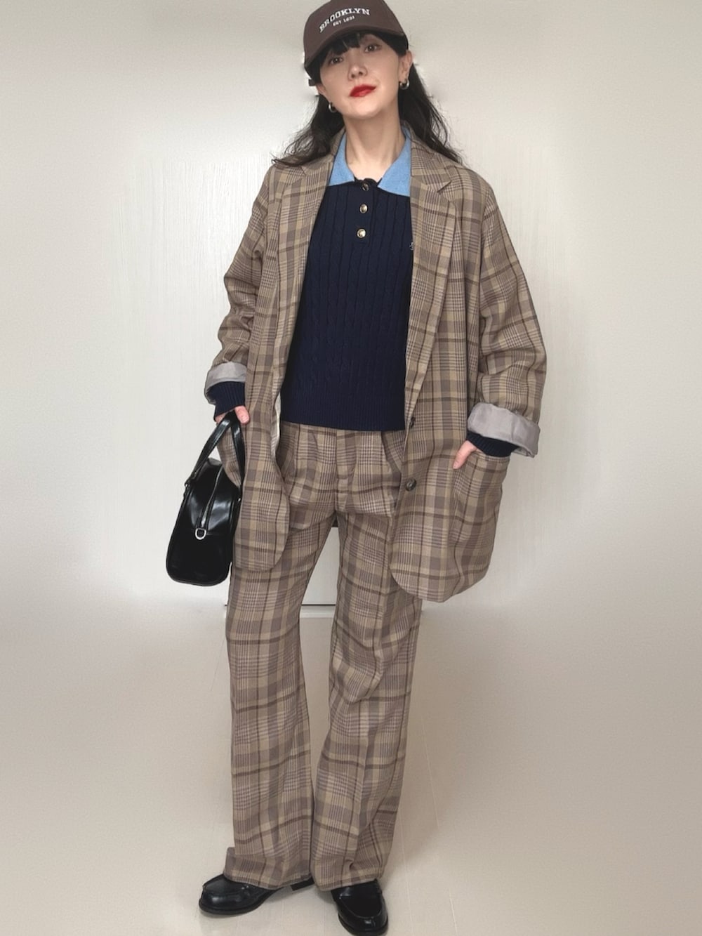 ブルー系のニット/セーター、ブラック系のボストンバッグ、ブラック系のローファーを着用したレディースの冬コーディネートの5枚目の写真