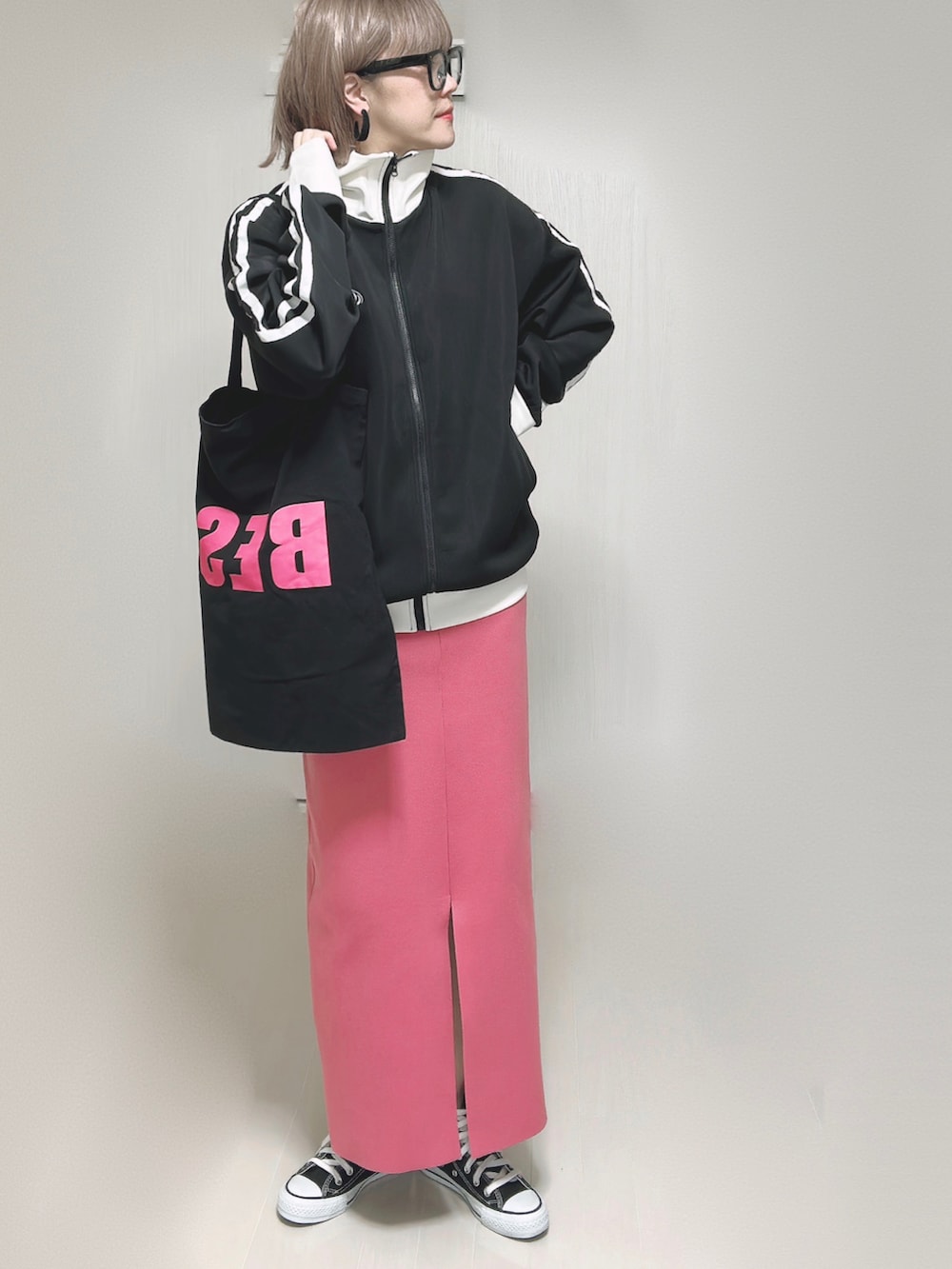 ブラック系のブルゾン、ブラック系のトートバッグ、ピンク系のスカートを着用したレディースの秋コーディネートの4枚目の写真