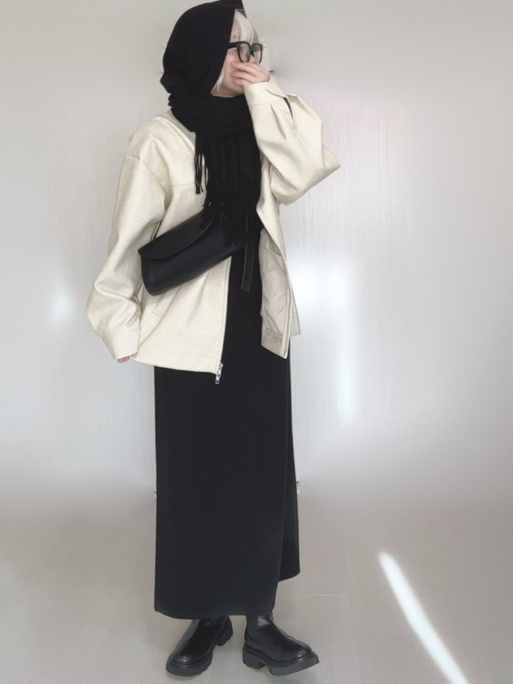 ホワイト系のブルゾン、ブラック系のワンピース、その他のバレエシューズを着用したレディースの冬コーディネートの3枚目の写真