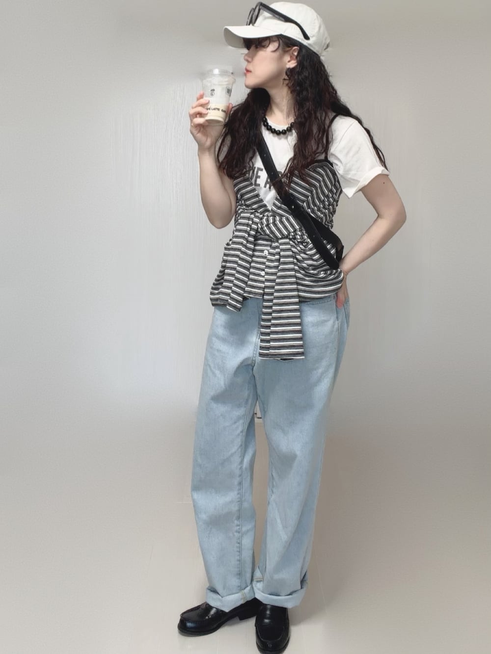 ホワイト系のTシャツ/カットソー、グレー系のカーディガン/ボレロ、ブルー系のデニムパンツを着用したレディースの春コーディネートの4枚目の写真
