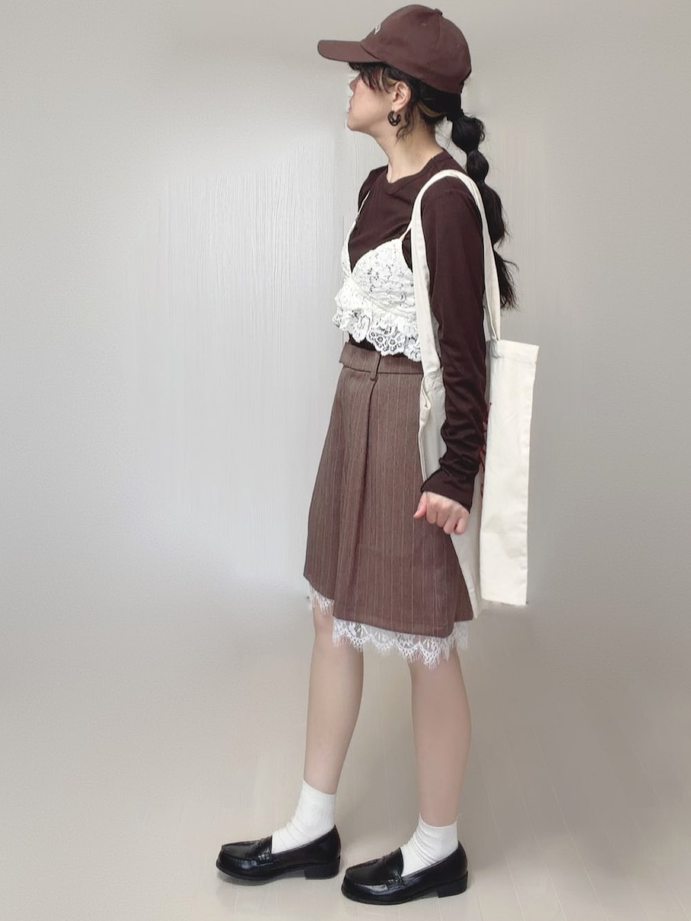 ホワイト系のキャミソール、ブラウン系のその他パンツ、ホワイト系のトートバッグを着用したレディースの春コーディネートの5枚目の写真