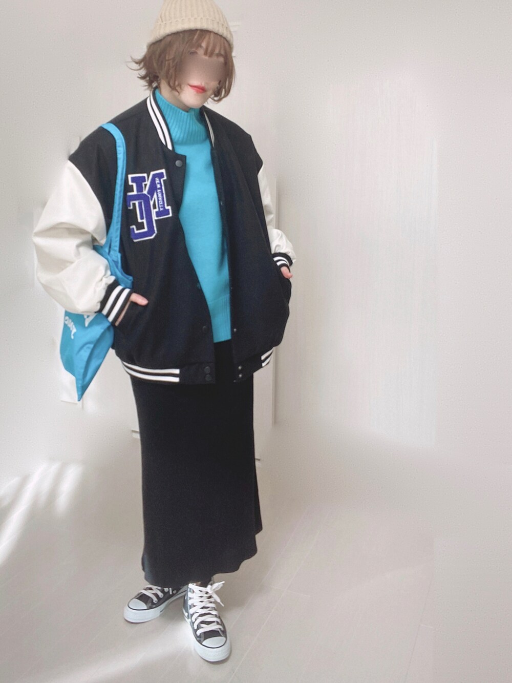 ブルー系のニット/セーター、ブラック系のスタジャン、ブルー系のトートバッグを着用したレディースの冬コーディネートの4枚目の写真