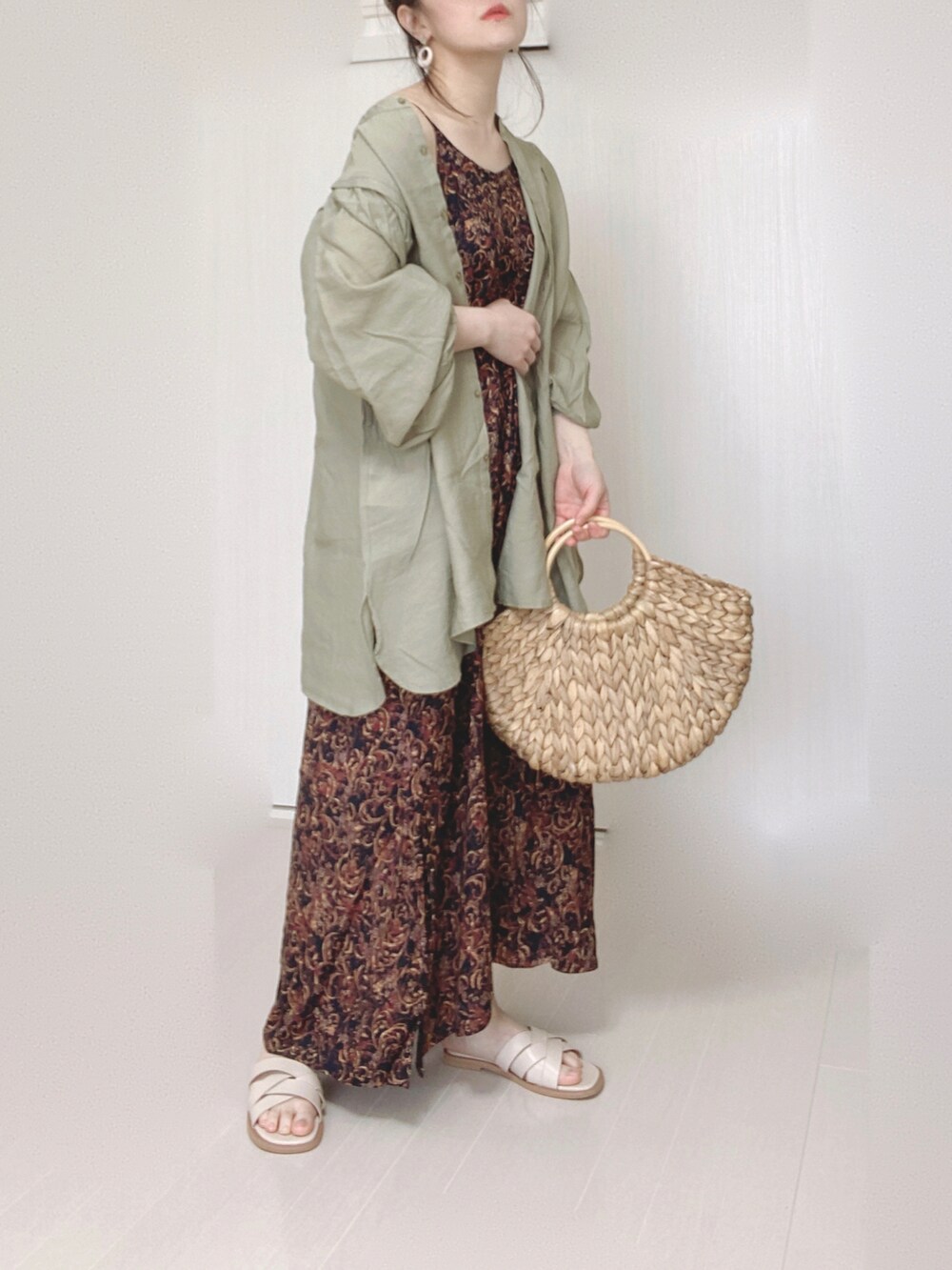 ブラック系のワンピース、グリーン系のシャツ/ブラウス、ホワイト系のサンダルを着用したレディースの春コーディネートの3枚目の写真