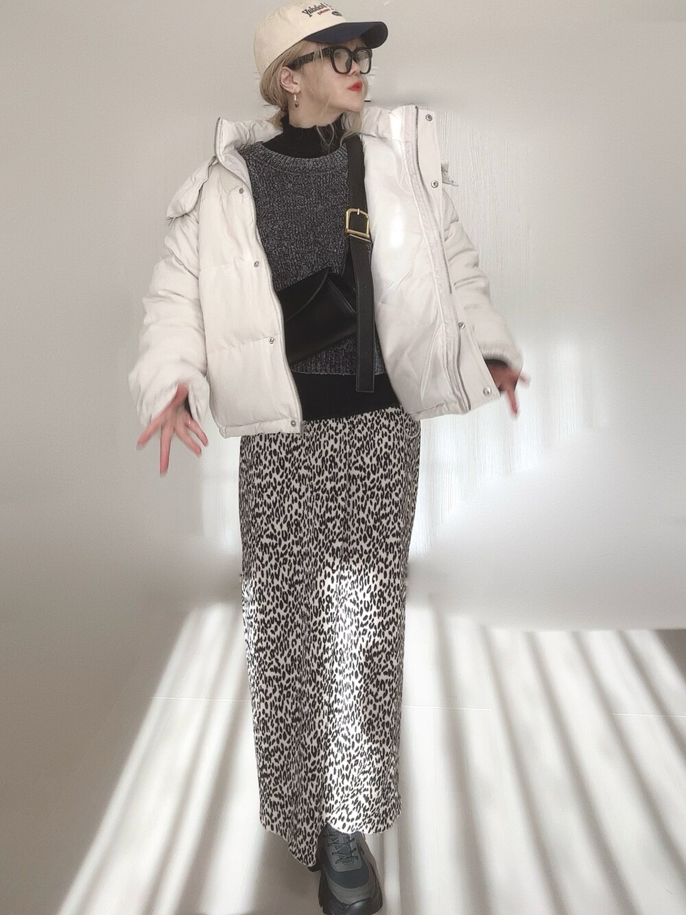 ブラック系のニット/セーター、ブラック系のTシャツ/カットソー、ホワイト系のダウンジャケット/コートを着用したレディースの冬コーディネートの4枚目の写真