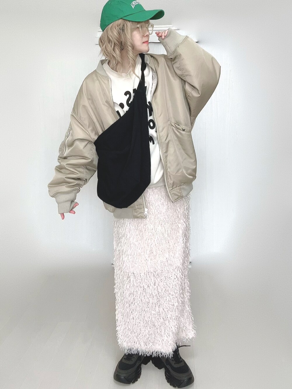 ベージュ系のMA-1、ブラック系のスニーカー、イエロー系のメガネを着用したレディースの春コーディネートの4枚目の写真