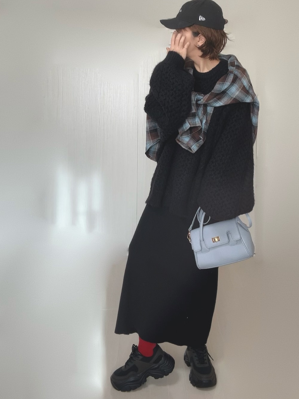 ブラウン系のシャツ/ブラウス、ブラック系のニット/セーター、ブラック系のスカートを着用したレディースの冬コーディネートの2枚目の写真