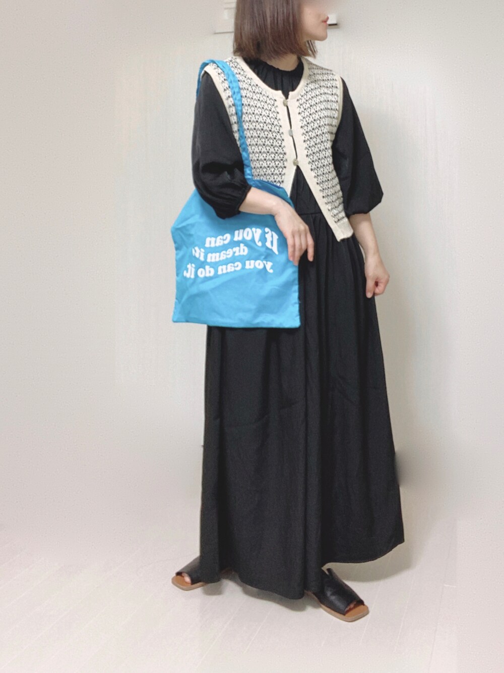 ブラック系のワンピース、ブルー系のトートバッグ、ブラック系のサンダルを着用したレディースの夏コーディネートの4枚目の写真