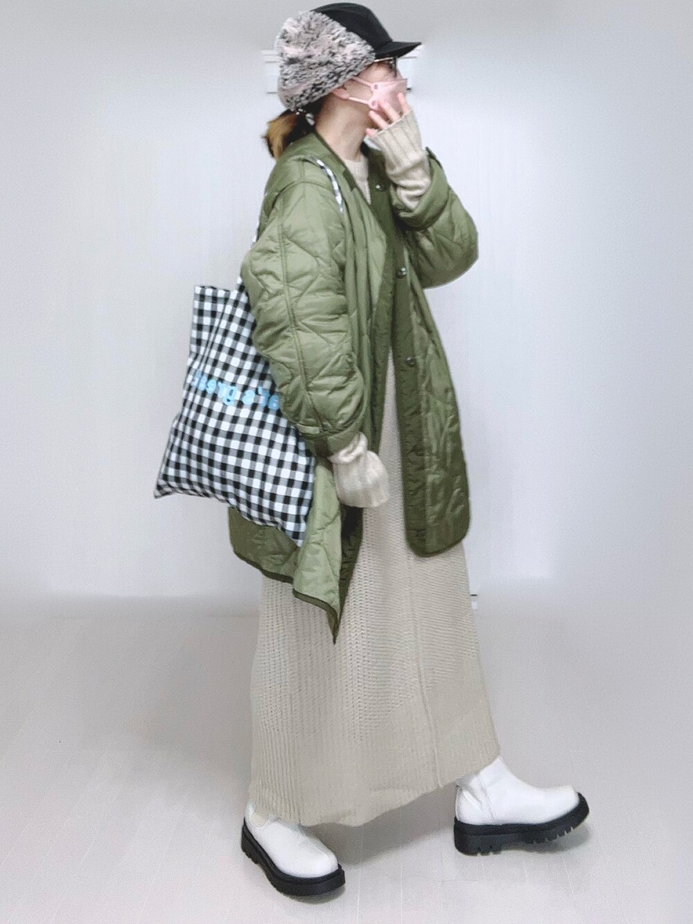 ホワイト系のワンピース、グリーン系のミリタリージャケット、ホワイト系のブーツを着用したレディースの冬コーディネートの5枚目の写真