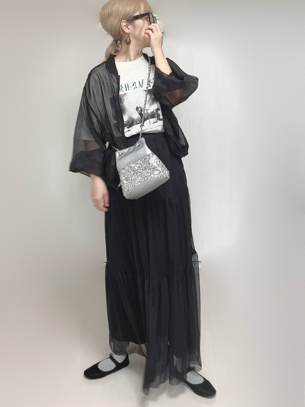 ブラック系のスカート、ホワイト系のTシャツ/カットソー、シルバー系のショルダーバッグを着用したレディースの秋コーディネートの2枚目の写真